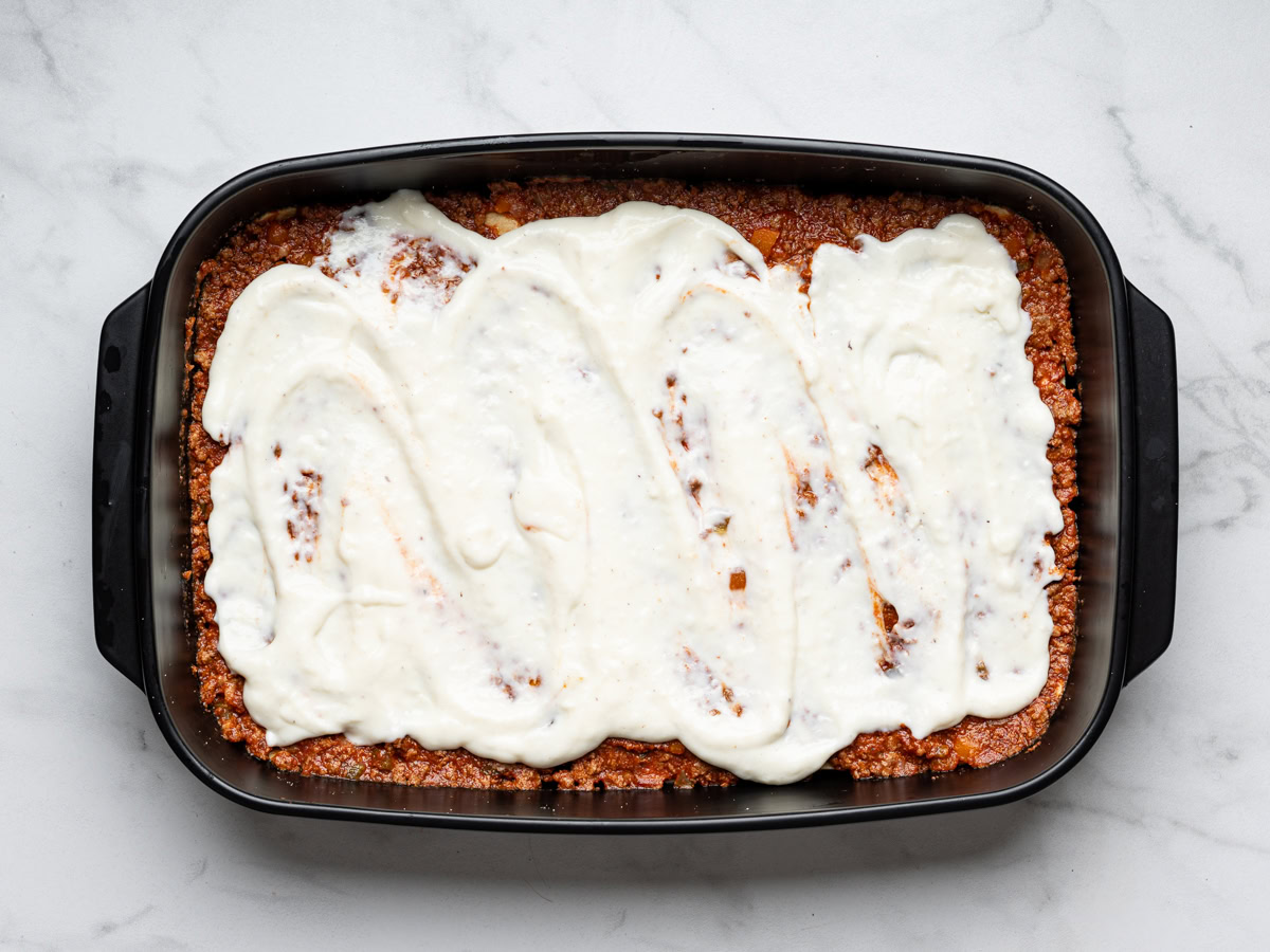 bechamel sauce drizzled over bolognese