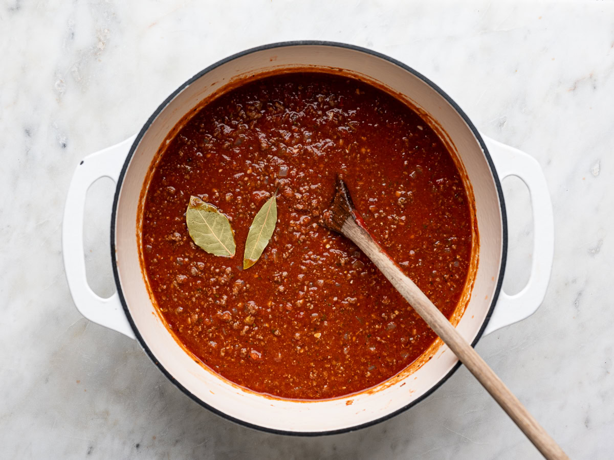 sauce in pot with bay leaves before simmering