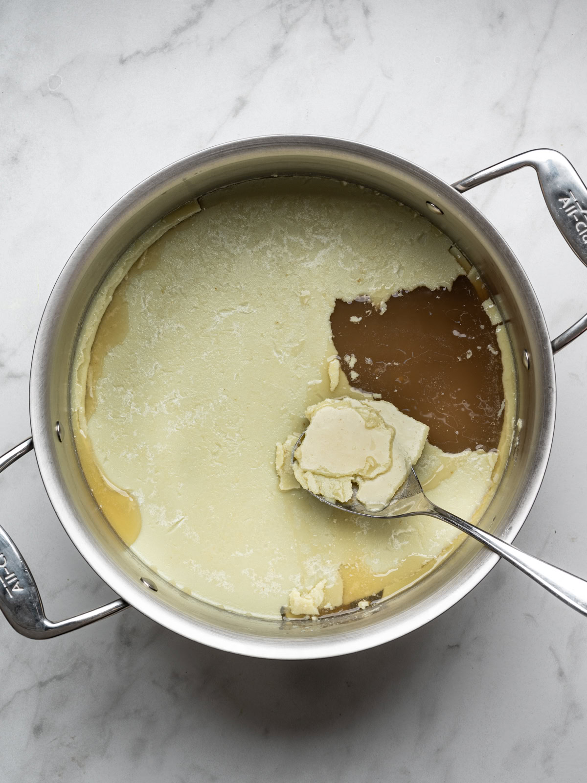 removing some of the congealed layer of fat with a large spoon