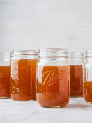 closeup of five mason jars filled with slow cooker bone broth