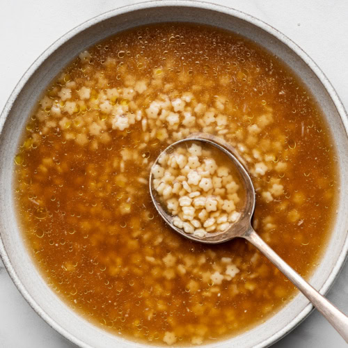 Top view of Pastina soup served in a bowl with a spoon