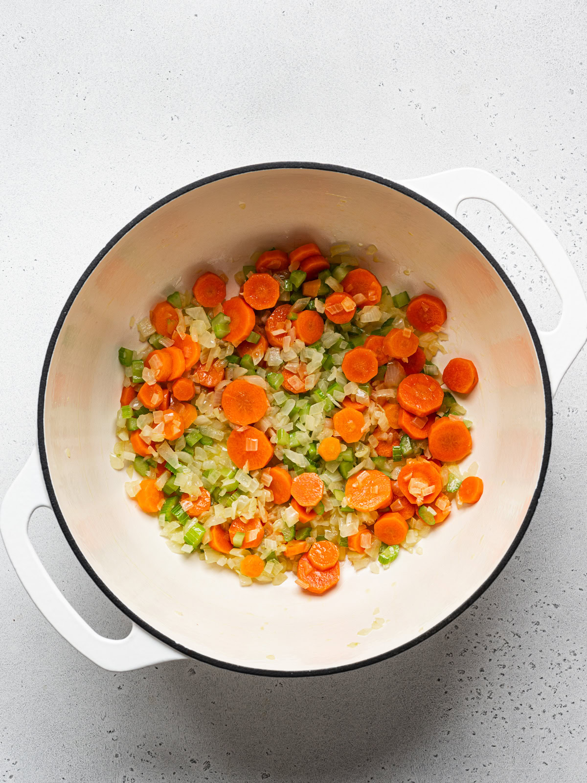 onion, carrot and celery sautéed in large white pot