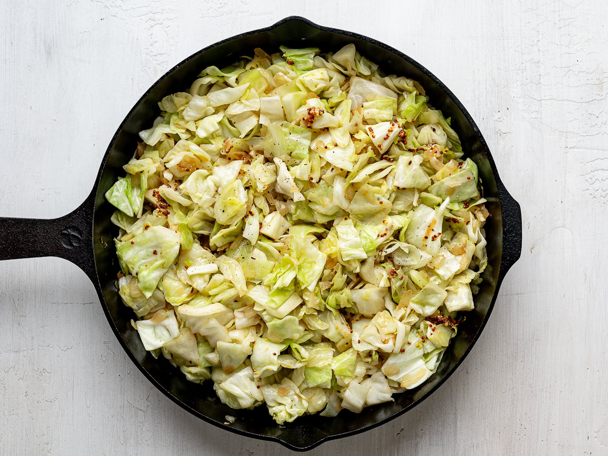 Cooked cabbage mixture in black skillet.