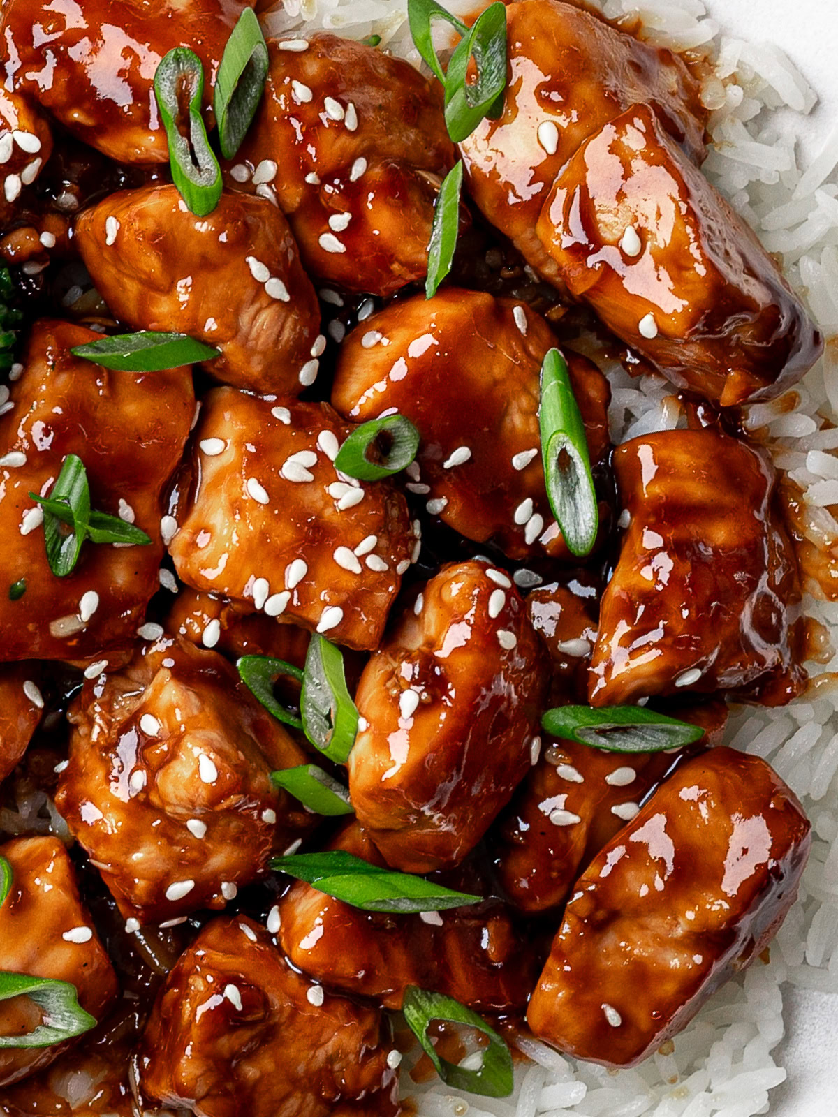 Closeup of Teriyaki chicken served over fluffy white rice. 