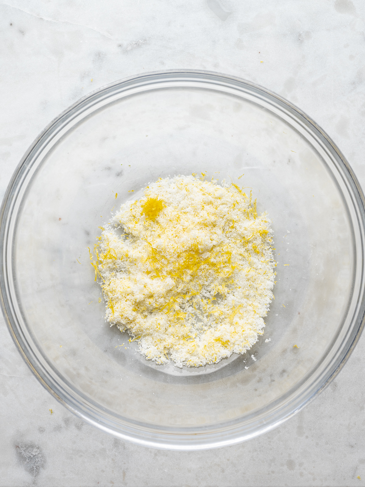 Lemon zest and sugar combined in a large mixing bowl.