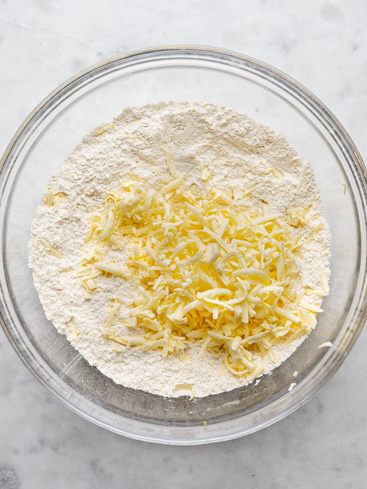 grated butter added to bowl with dry ingredients.