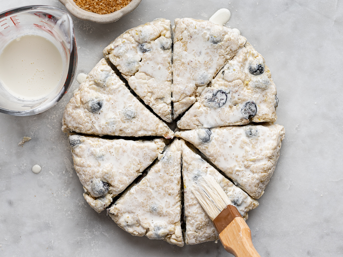 Brushing top of scones with milk.