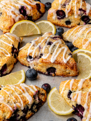 Side-view of lemon blueberry scones with lemon glaze drizzled over the top.