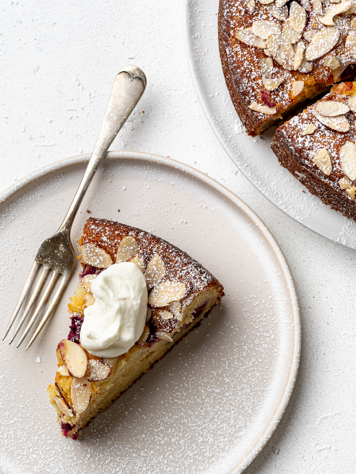 A slice of raspberry ricotta cake on a small plate with a fork.