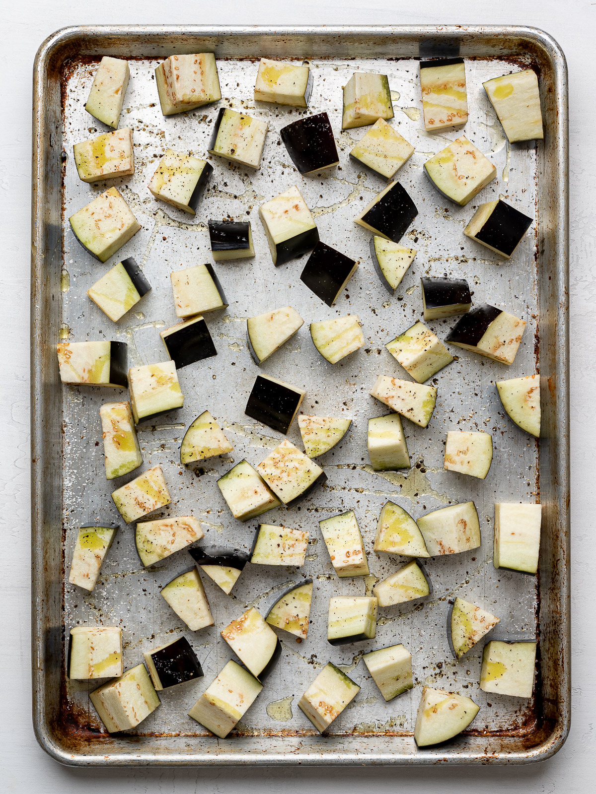 Raw cubed eggplant on a sheet pan. 