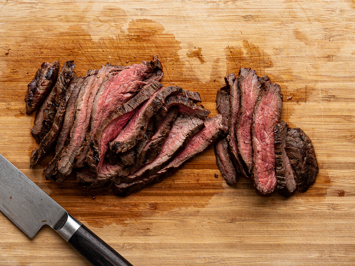 Grilled Flank steak sliced on a cutting board.