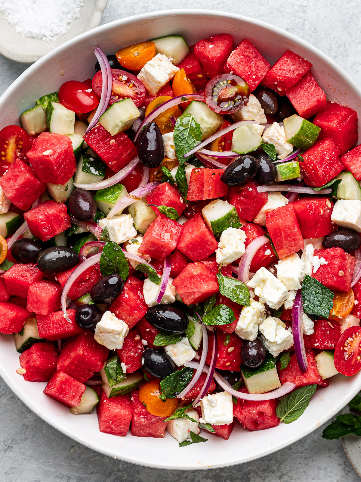 Close up of watermelon salad ingredients tossed together.