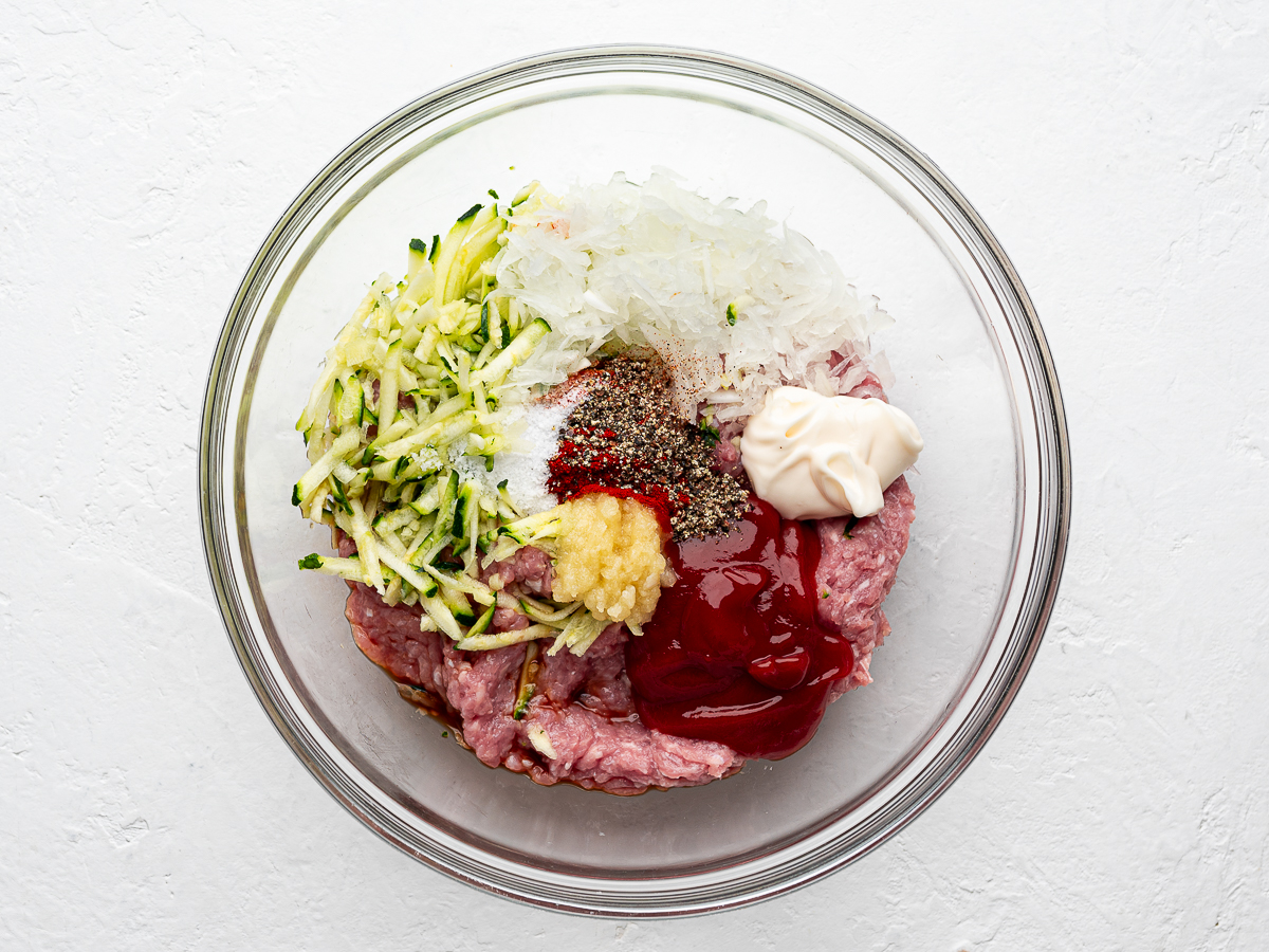 Ground turkey and zucchini mixture in glass bowl.