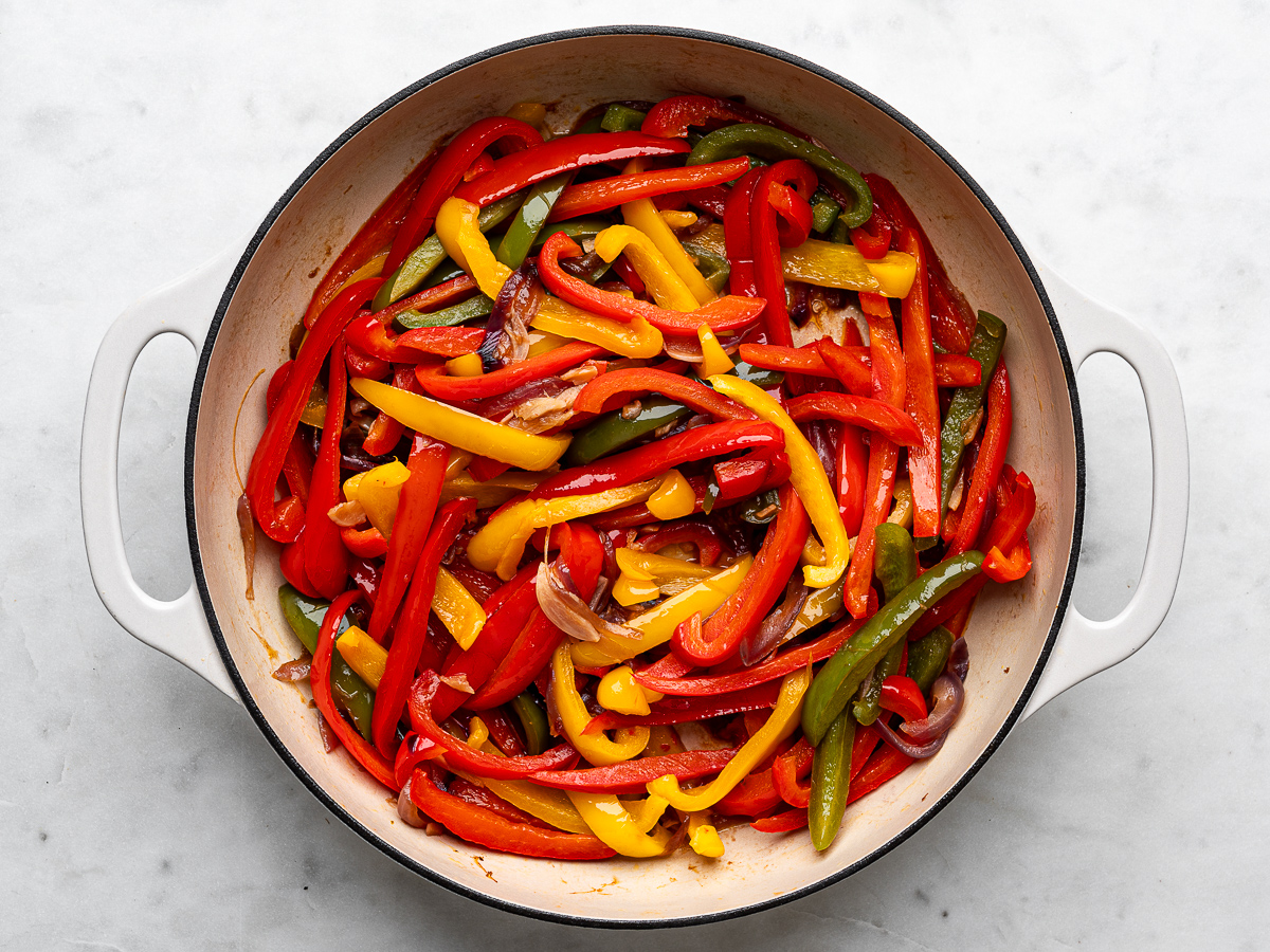 A mix of sweet bell peppers sautรฉed in pan with onion/garlic mixture.