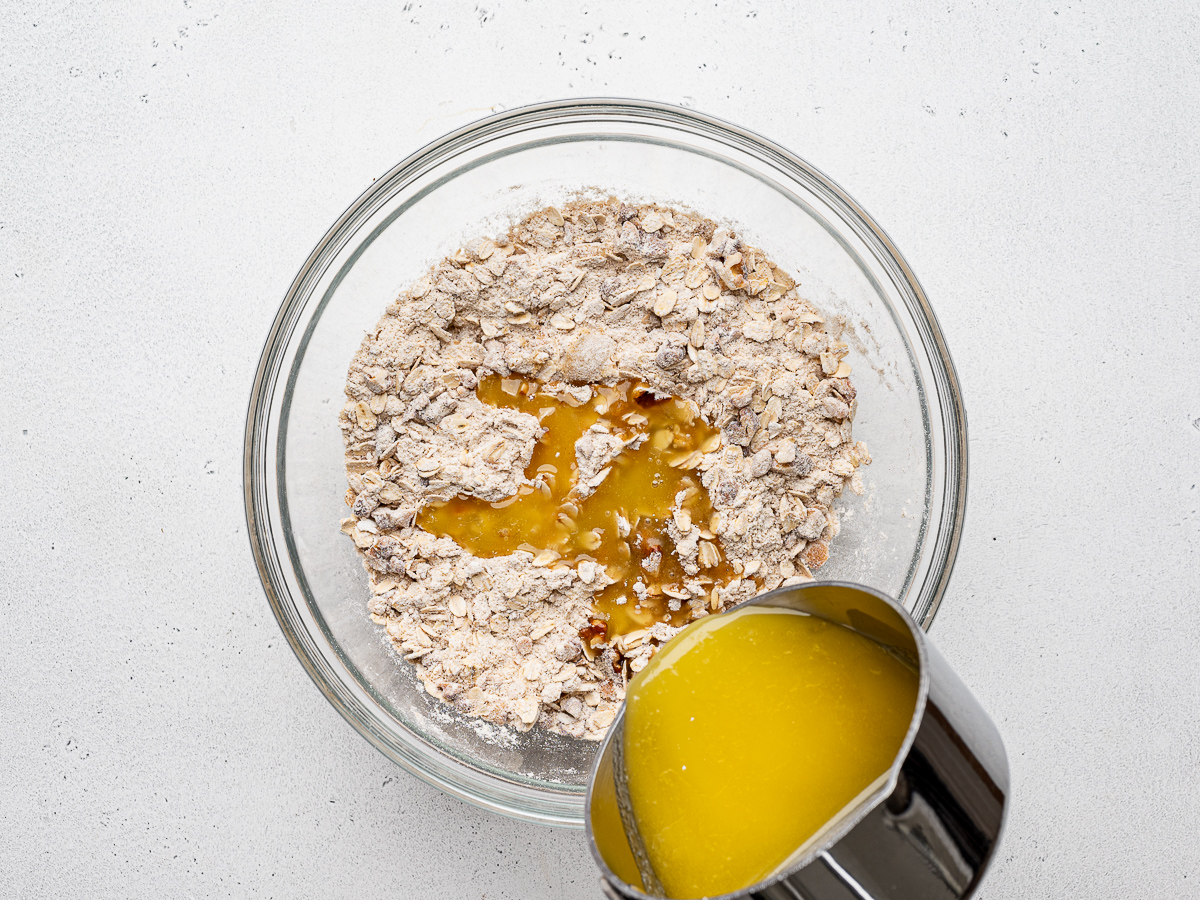 Pouring melted butter into topping mixture.