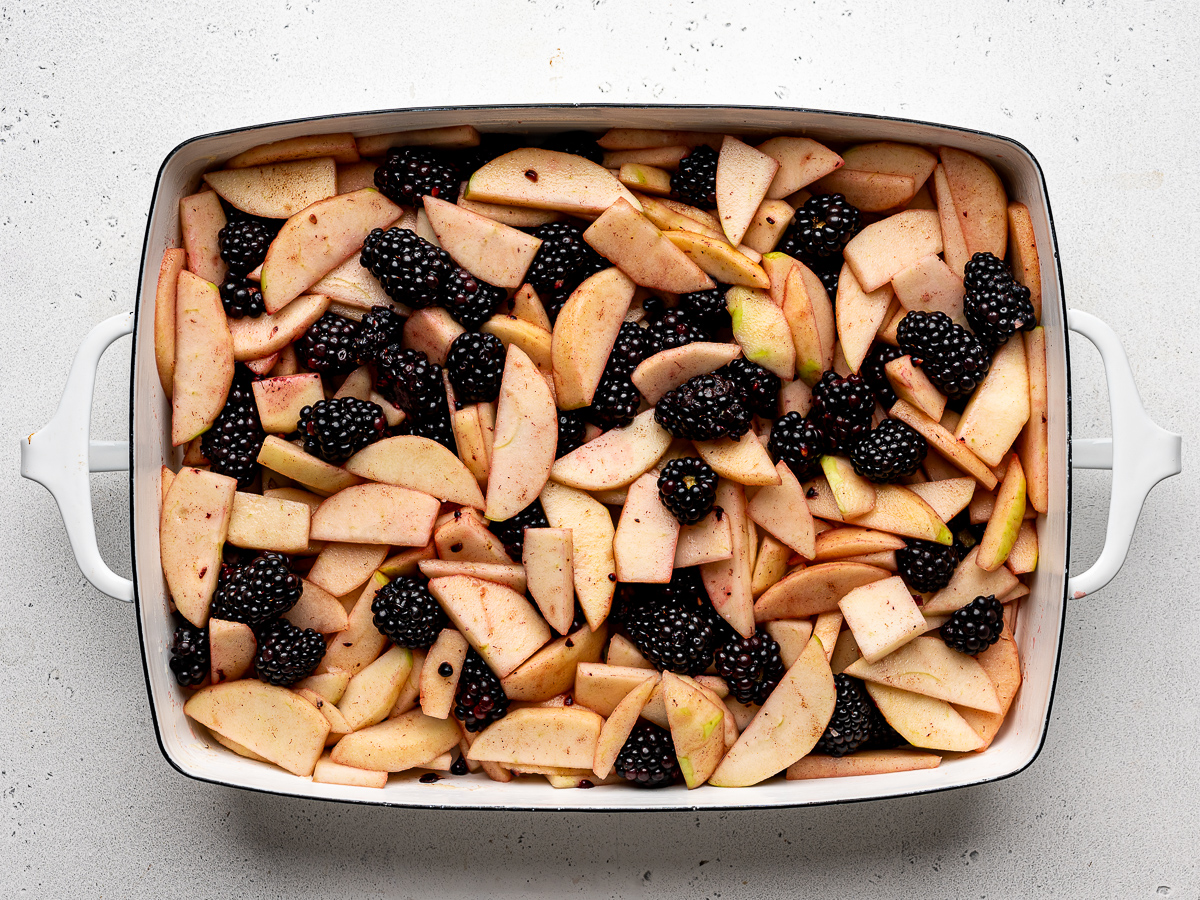 sliced apple and blackberry mixture in baking dish.