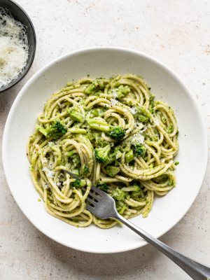 Broccoli Pasta served in white bowl with grated pecorino on the side.