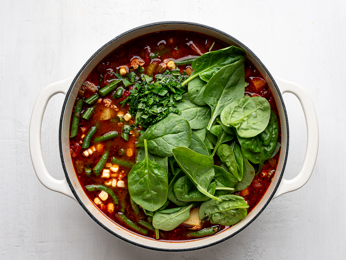 Baby spinach and chopped parsley added to the soup pot. 