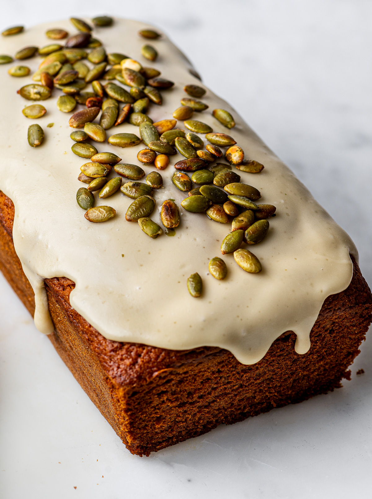 Close up of glazed loaf topped with pepitas.
