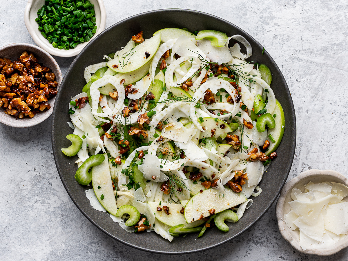 Assembled fennel and apple salad topped with toasted walnuts and manchego cheese. 