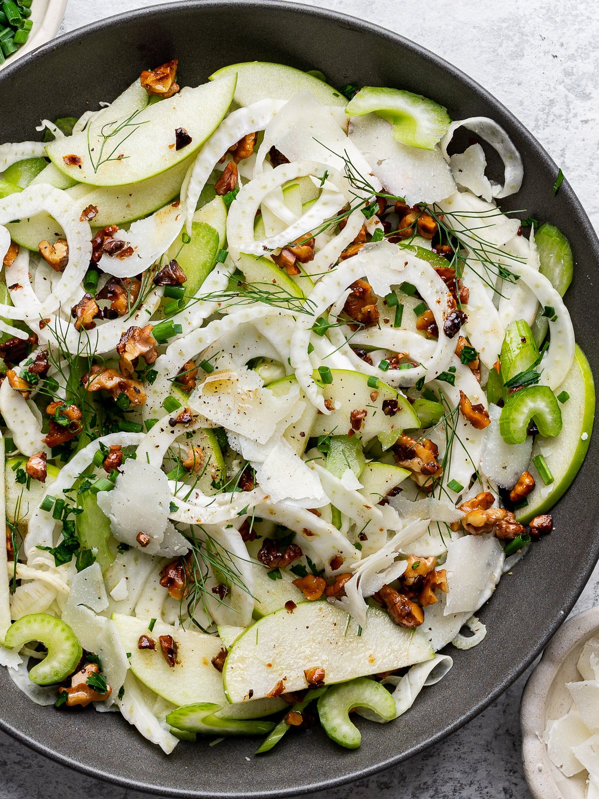 Close-up of assembled apple fennel salad in large grey bowl. 