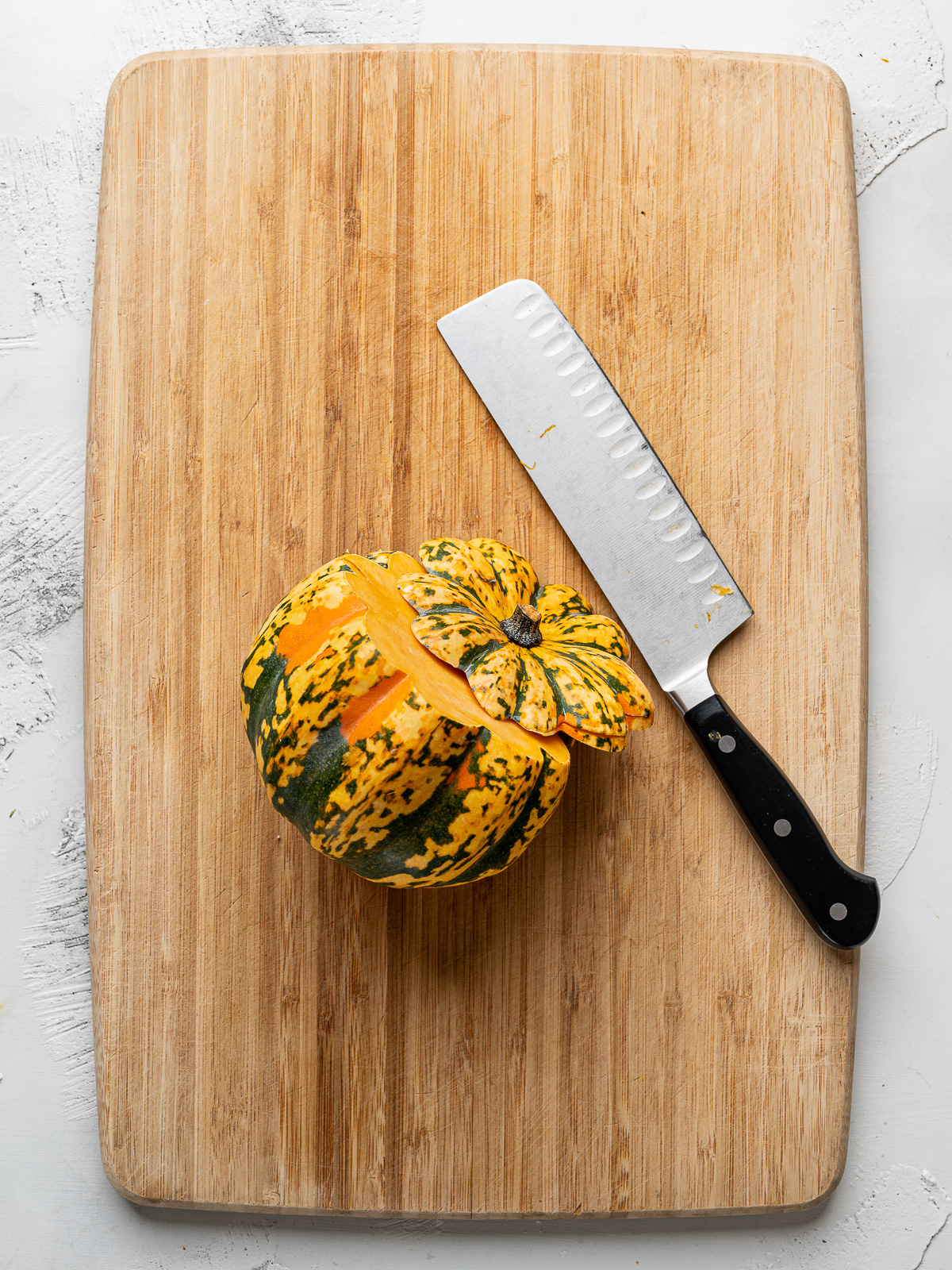Slicing the top off of the carnival squash. 