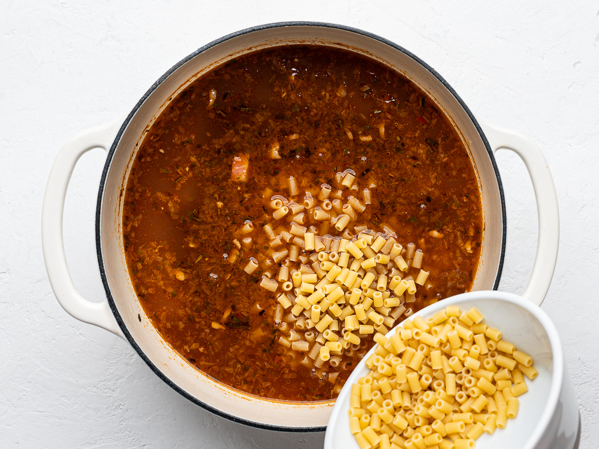 Adding small pasta shape to the bean soup. 