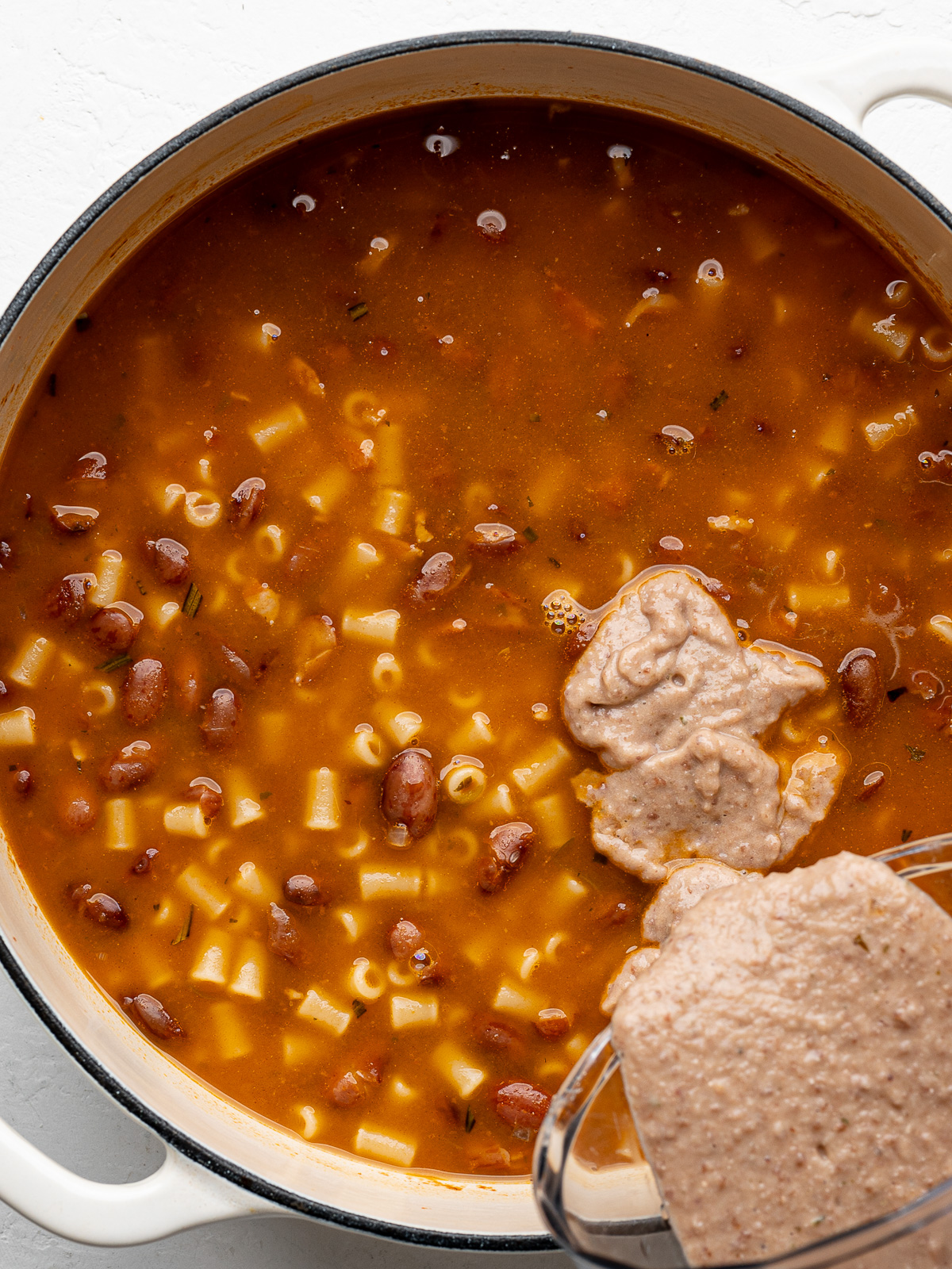 Adding pureed beans to bean and pasta soup.