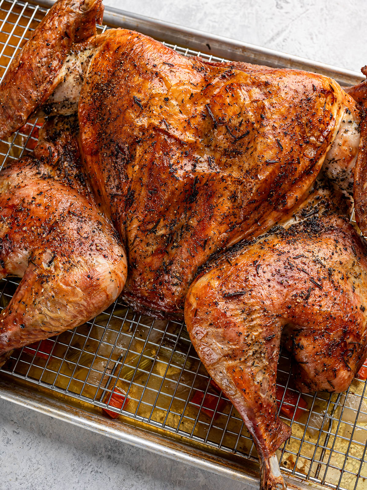Close-up of Cooked spatchcocked turkey on baking sheet.