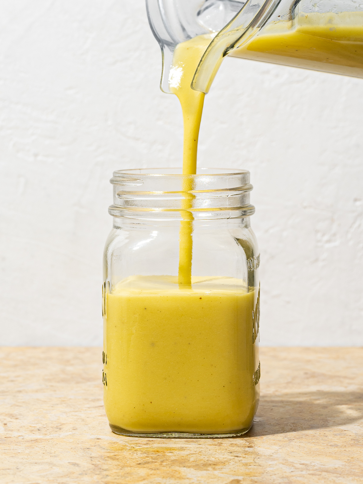 Pouring vinaigrette into mason jar. 