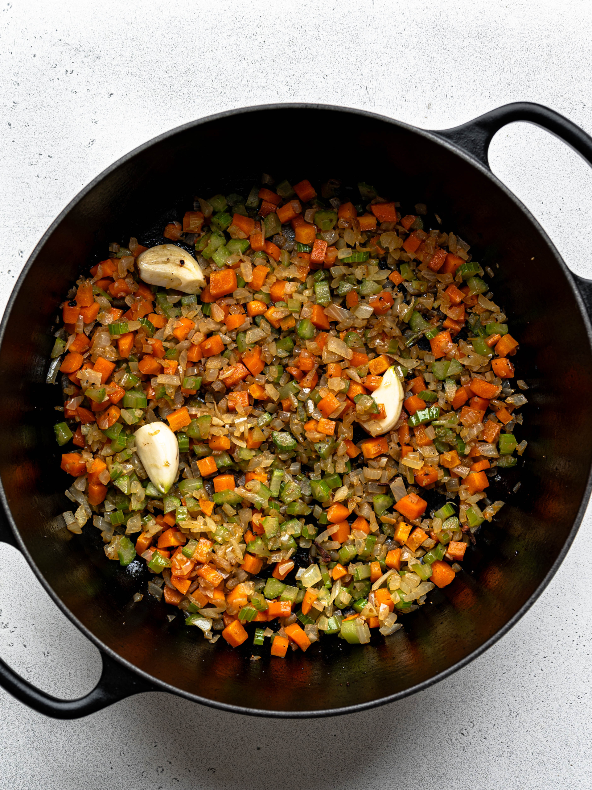Sofritto base (onions, celery, carrots, garlic) sautéing in large black Dutch oven. 