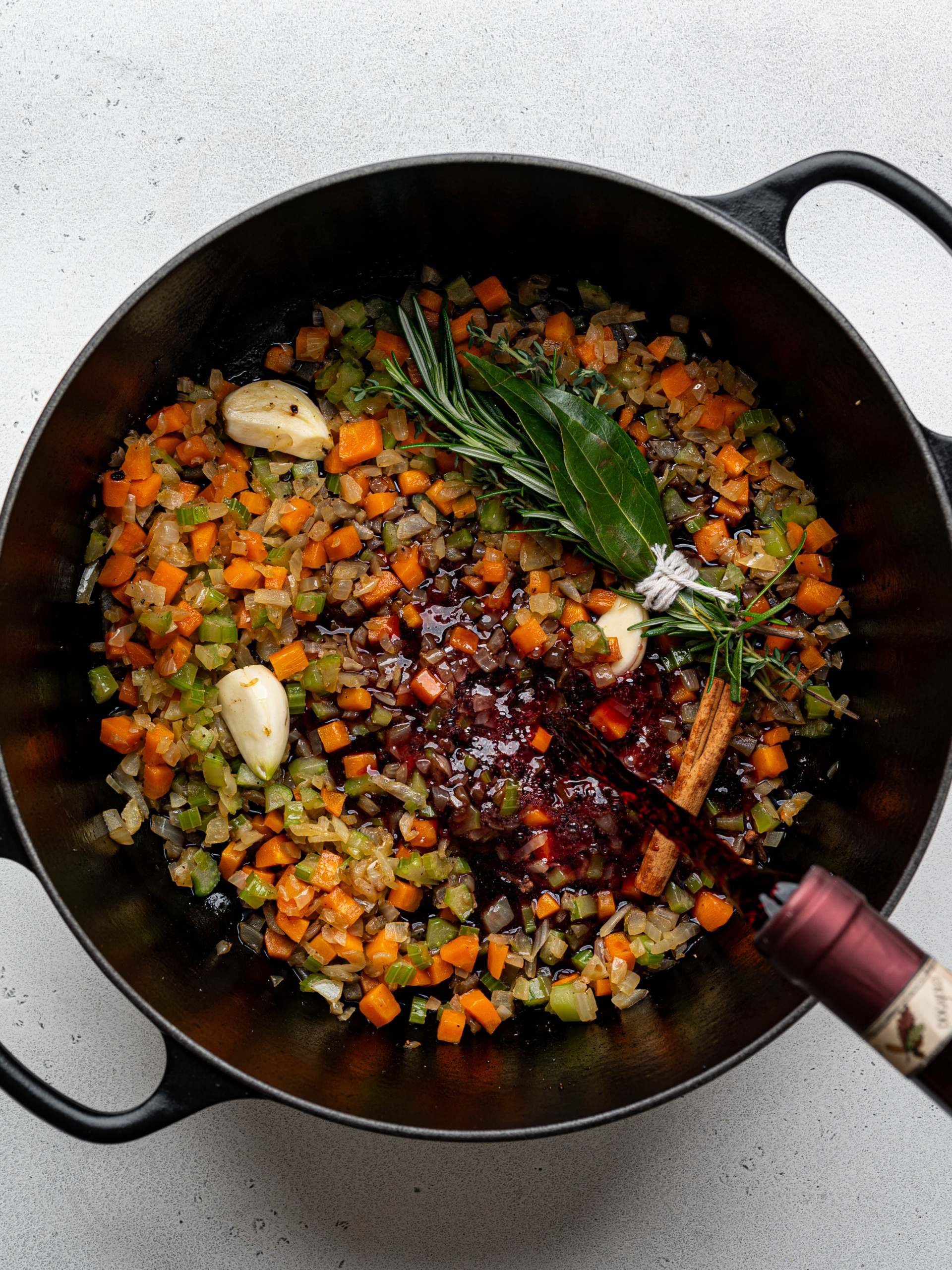 Pouring red wine over sautéed sofritto. 