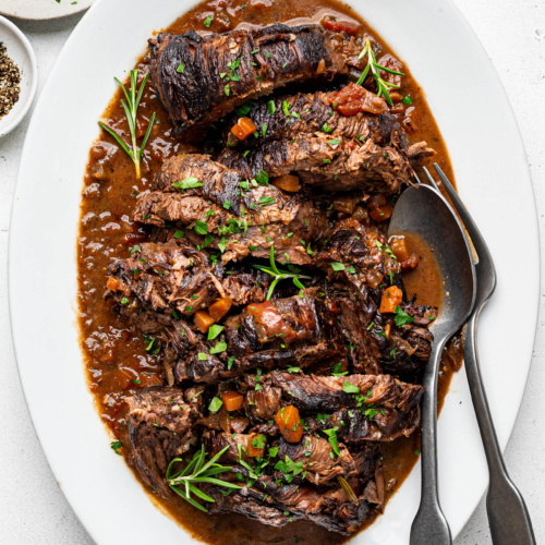 Sliced Stracatto di manzo (Italian pot roast) served on a large white platter.