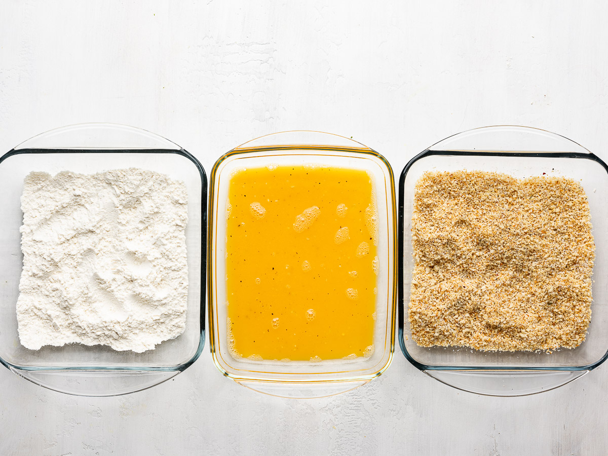 Three dredging bowls prepared with breadcrumbs, eggs and flour. 