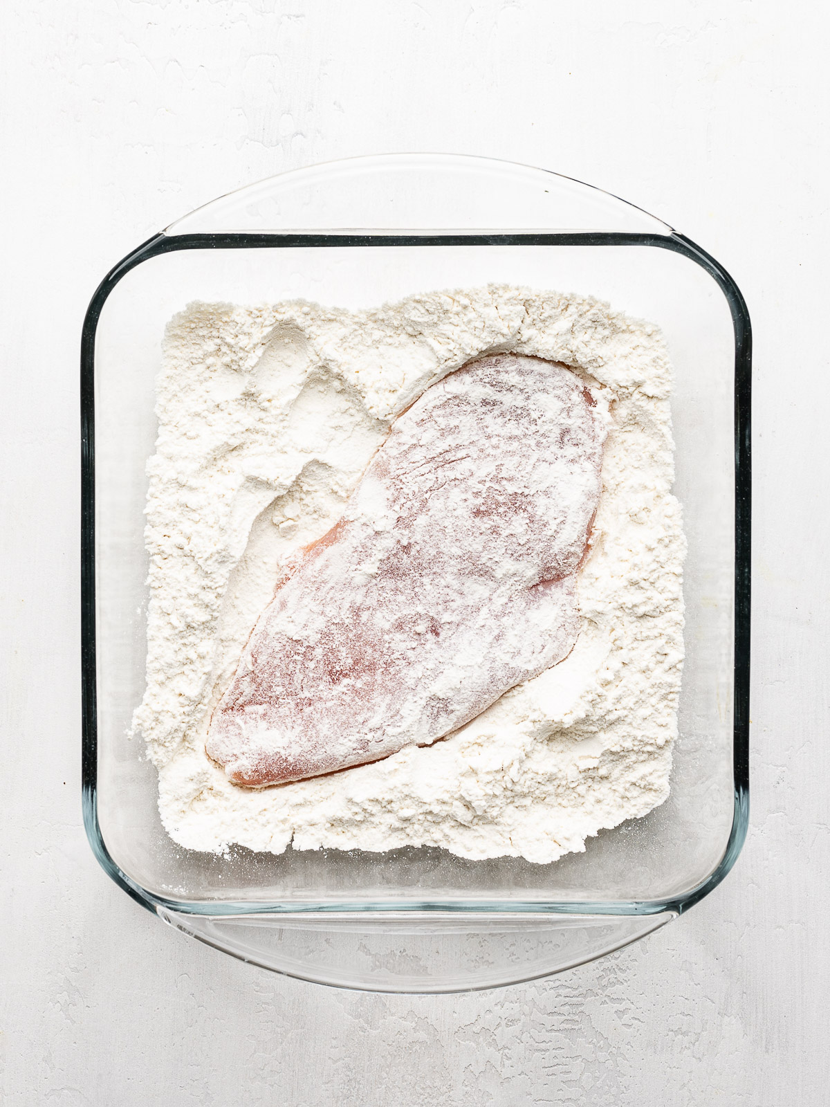 Chicken breast dredged in flour. 