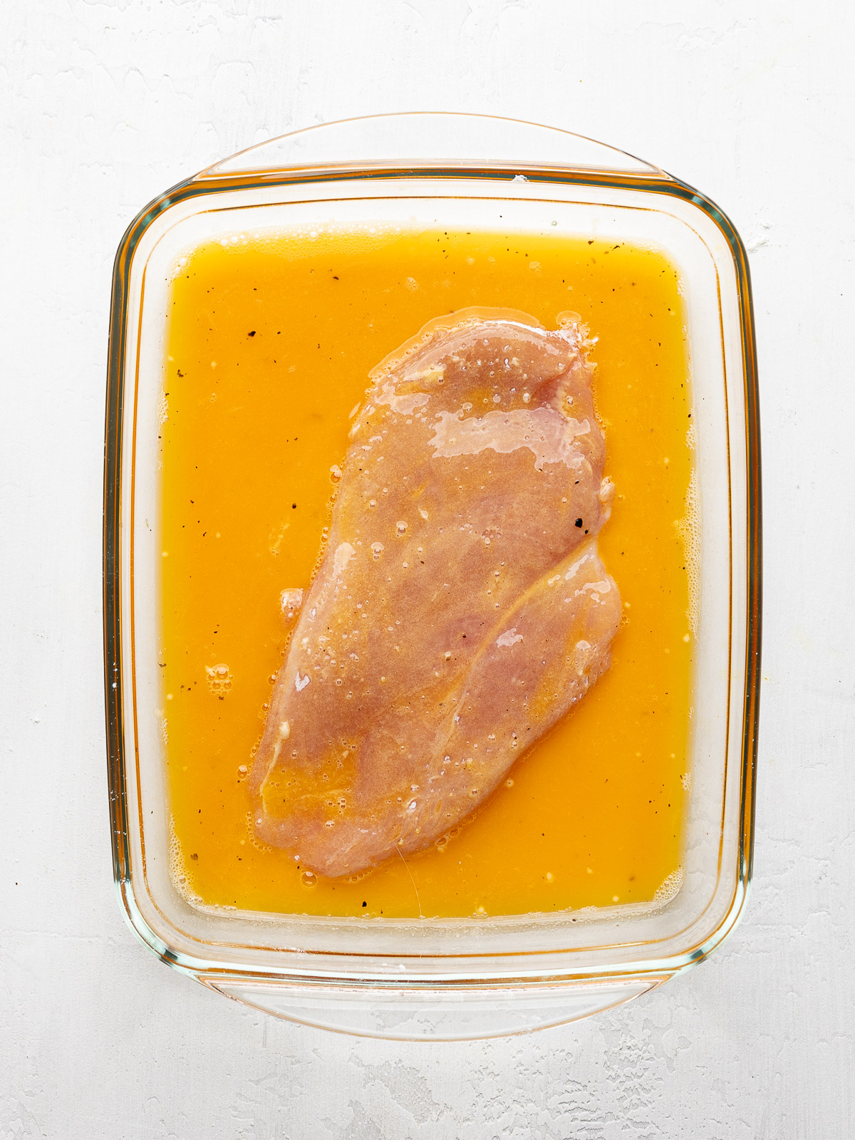Chicken breast dredged in egg mixture. 
