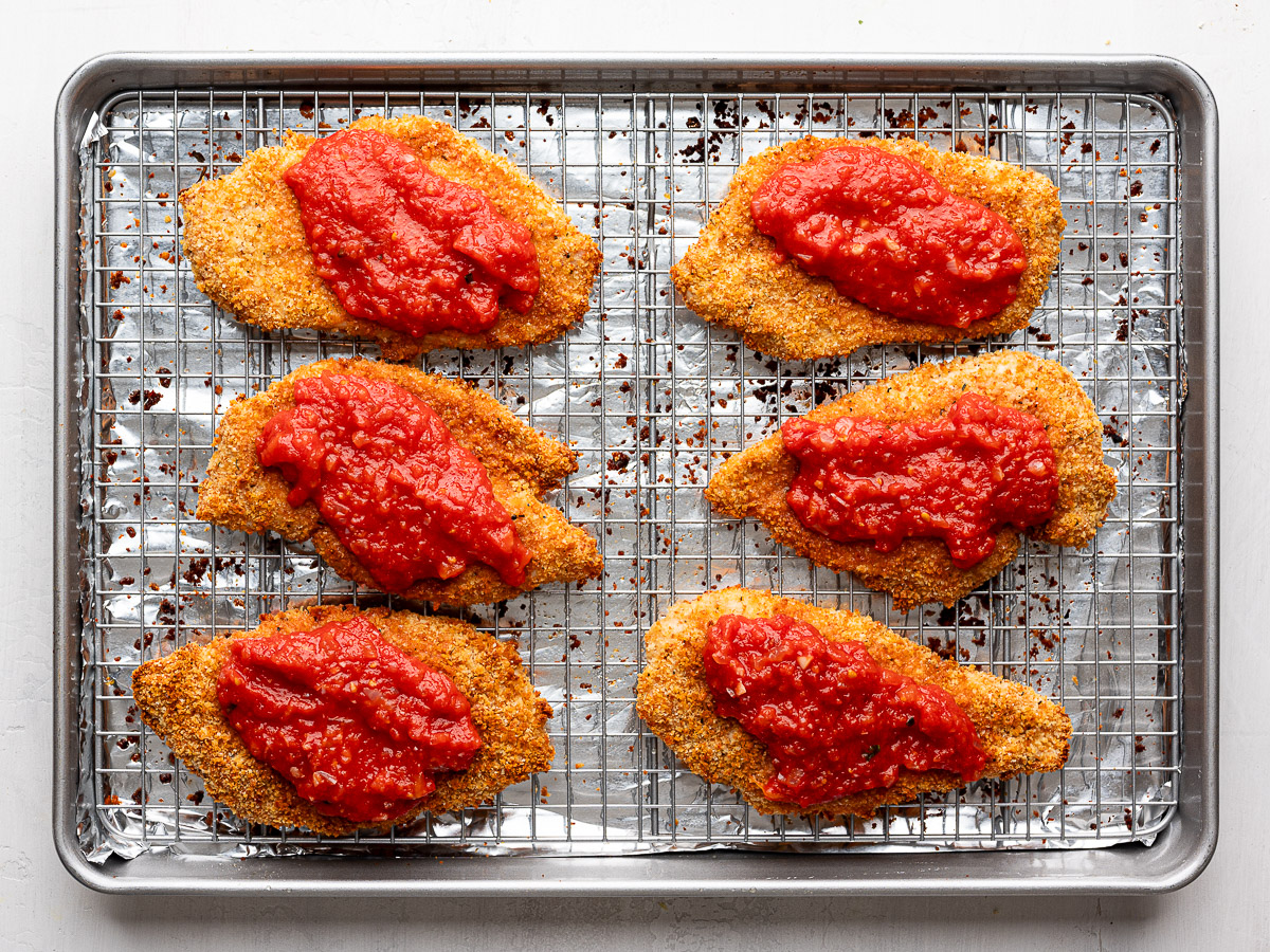 Six baked panko chicken cutlets topped with marinara sauce.