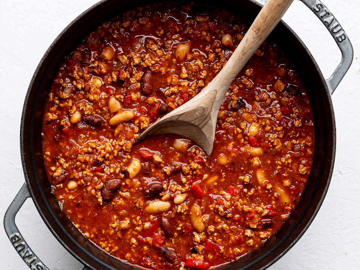 Cooked chili in tray pot with wooden spoon.