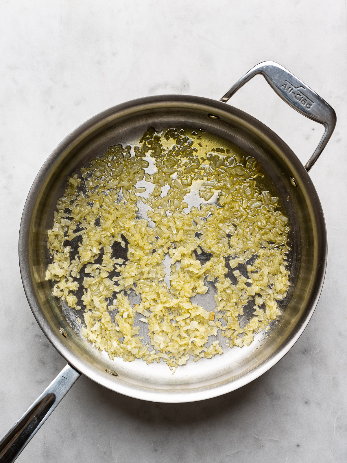 Sautéed Carnaroli rice in stainless steel skillet.