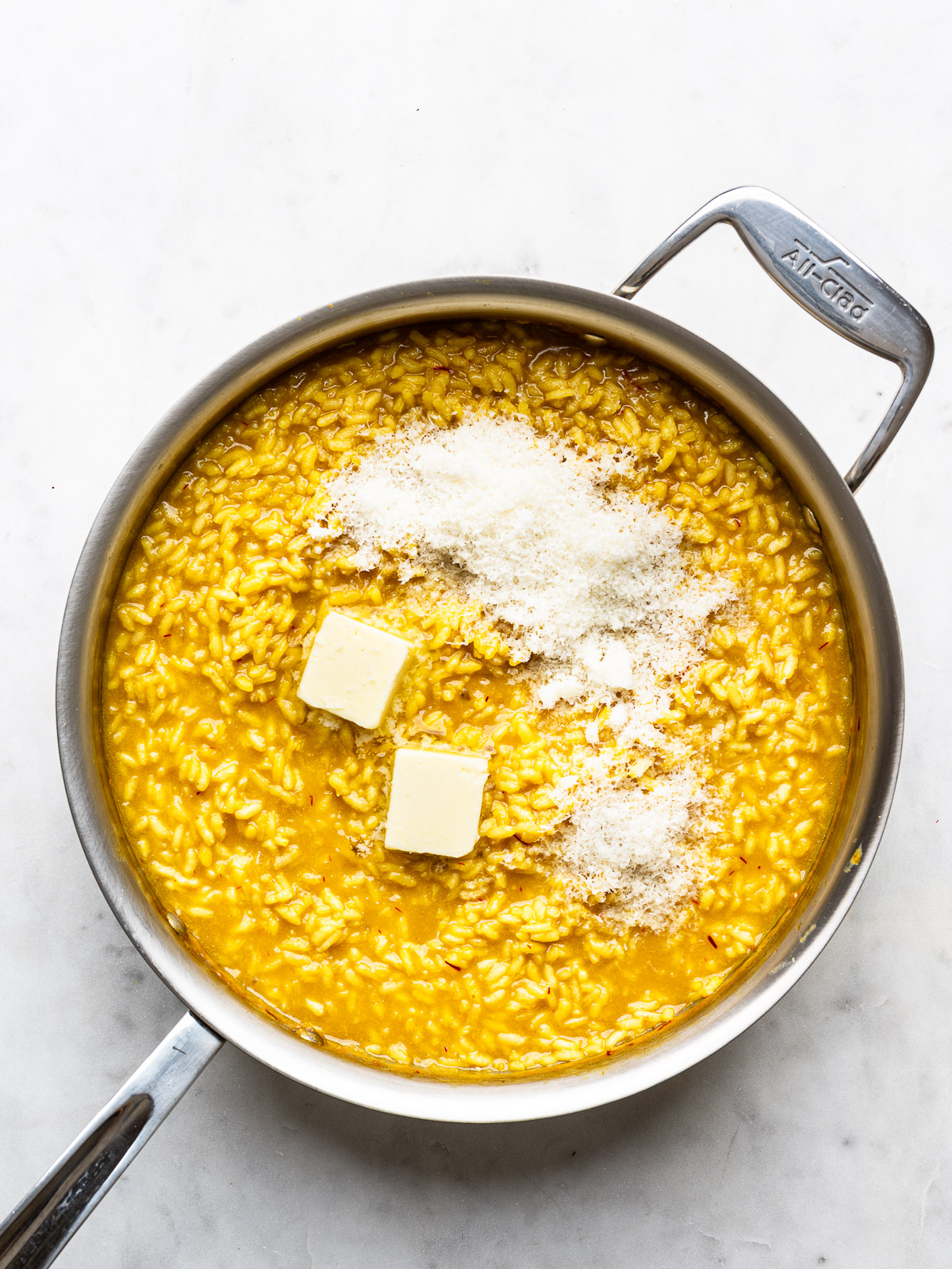 Stirring butter and parmesan into risotto.