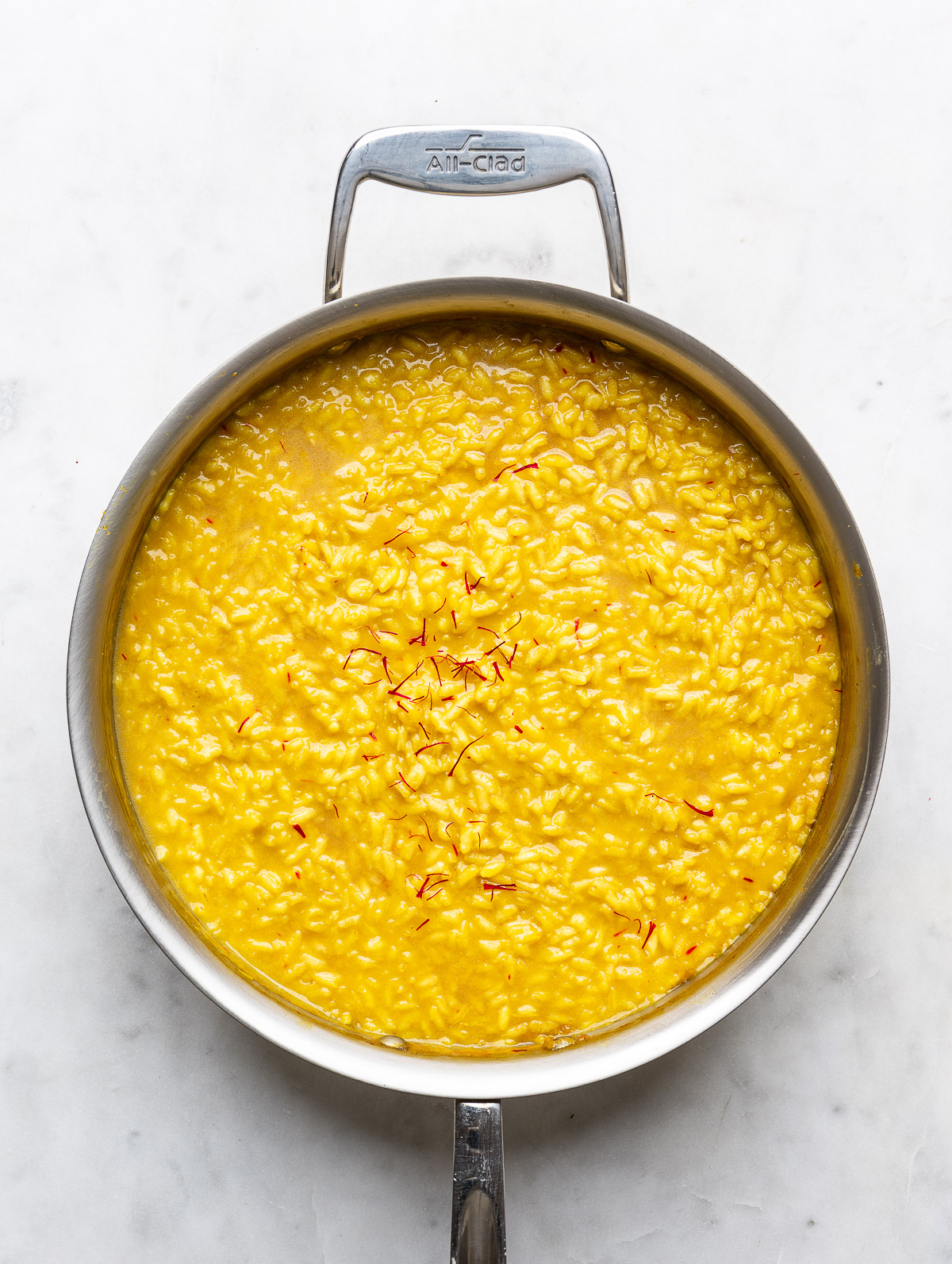 Finished saffron risotto in skillet.