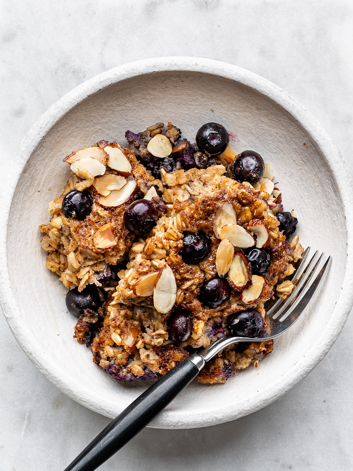 A scoop of baked oatmeal served in a white bowl. 