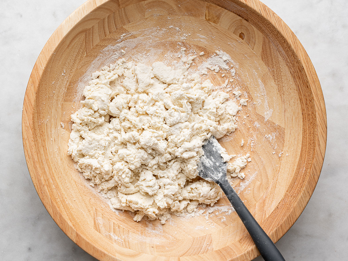 Shaggy mixed dough in wooden bowl. 
