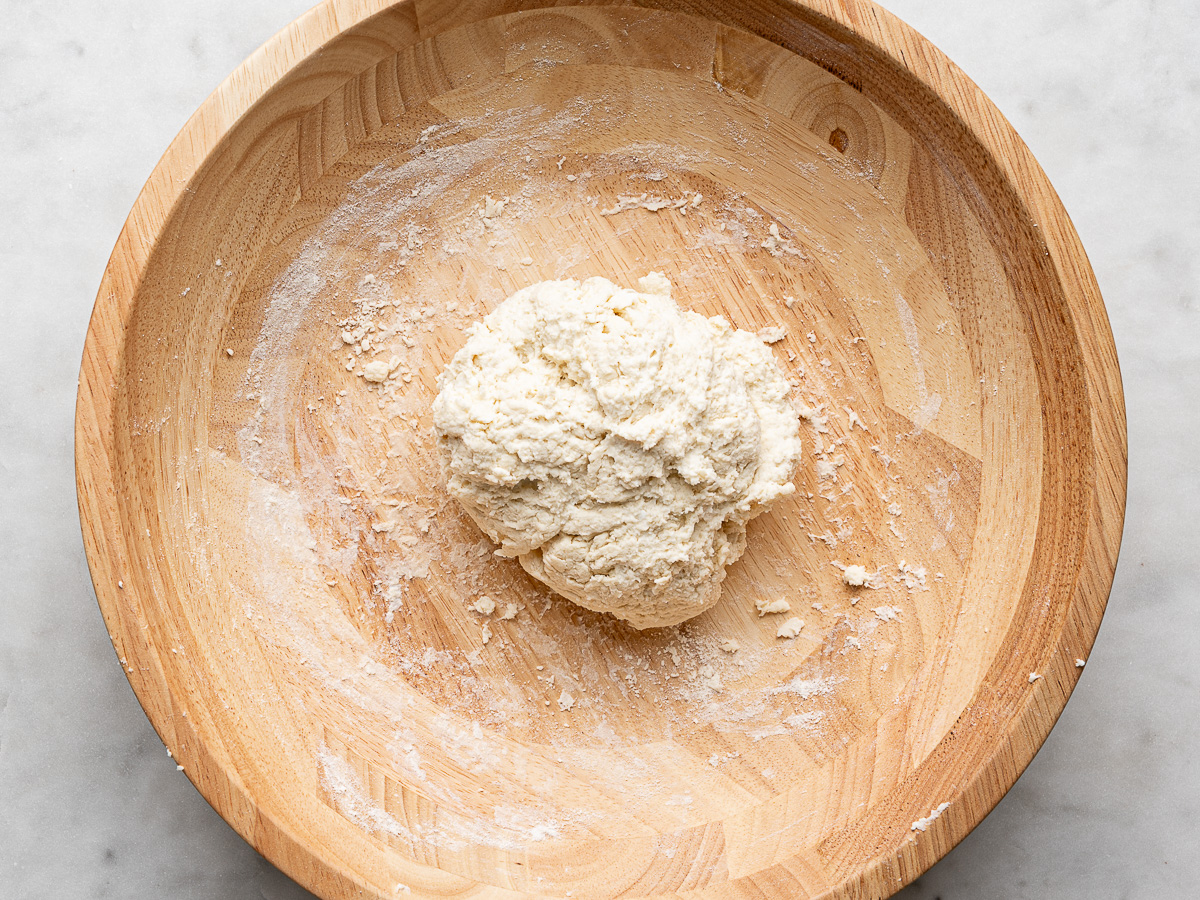 Formed ball of dough in wooden bowl. 