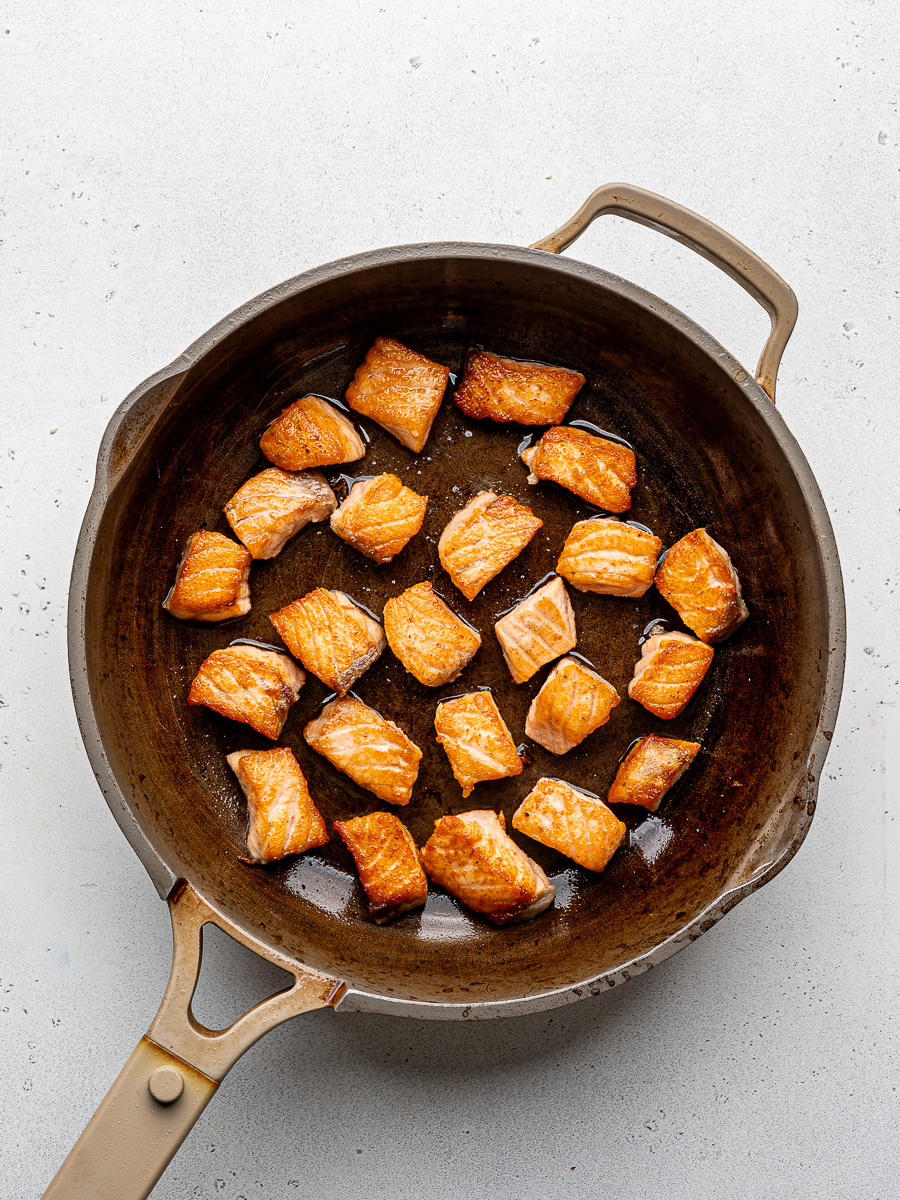 Salmon bites seared in a pan. 