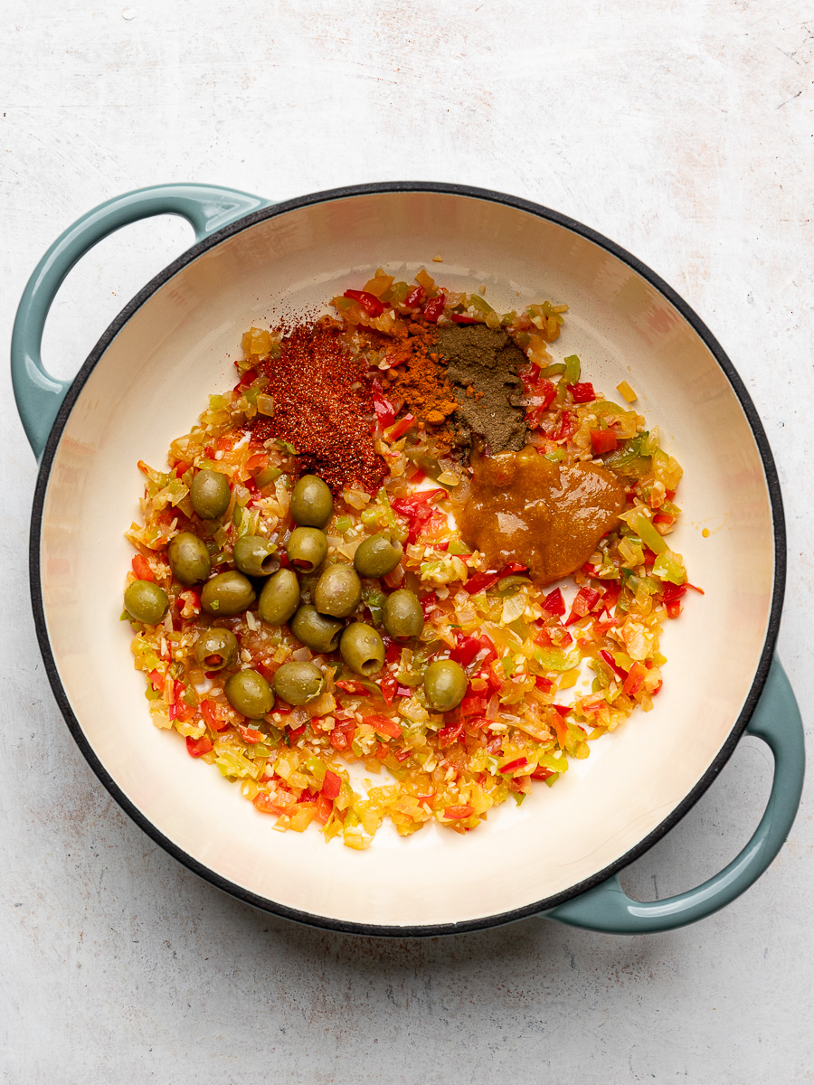 Sautéed aromatics, olives, and spices in pot. 