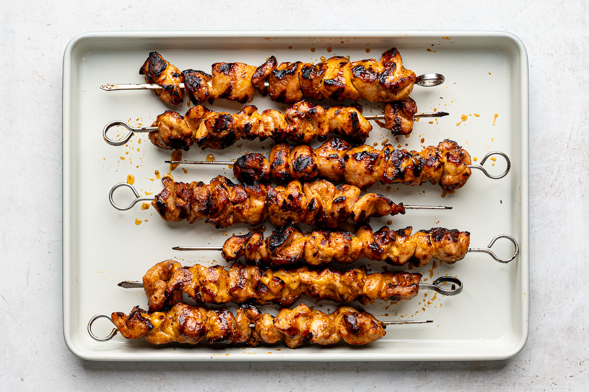 Grilled bang bang chicken skewers on a baking pan. 