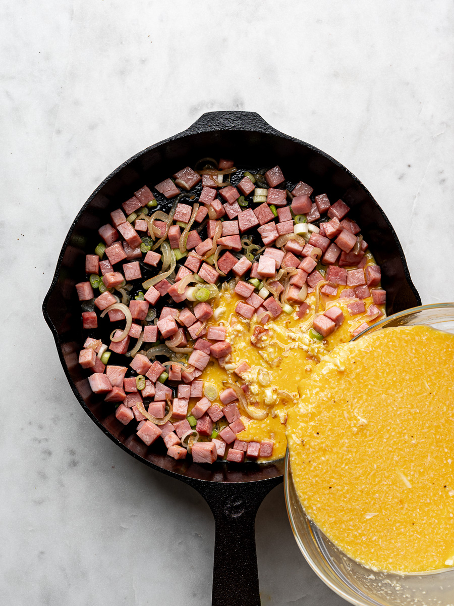Pouring egg mixture into skillet over the ham and onions. 