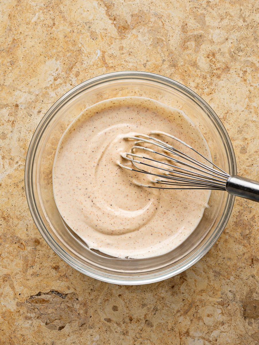 Crema dressing in a glass mixing bowl for Mexican chicken salad.