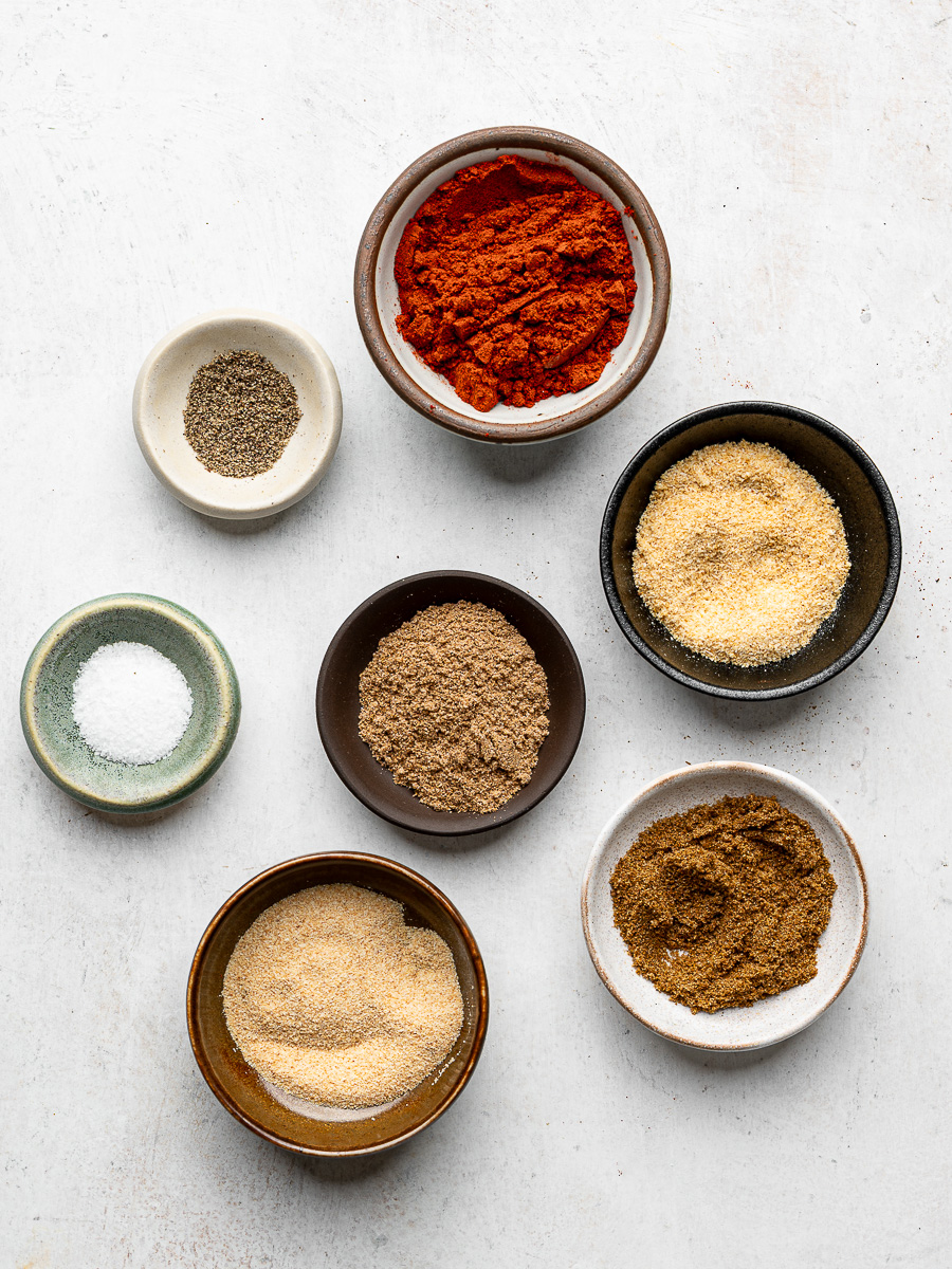Dried spices measured out in individual bowls. 
